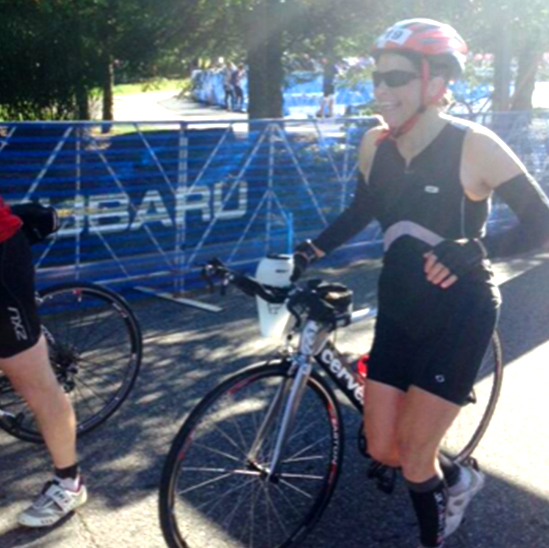 Jenn Harper running with her bike wearing helmets and sunglasses