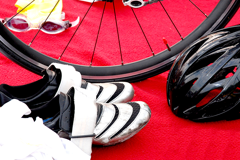 bike tire, bike shoes, and helmet on a red carpet